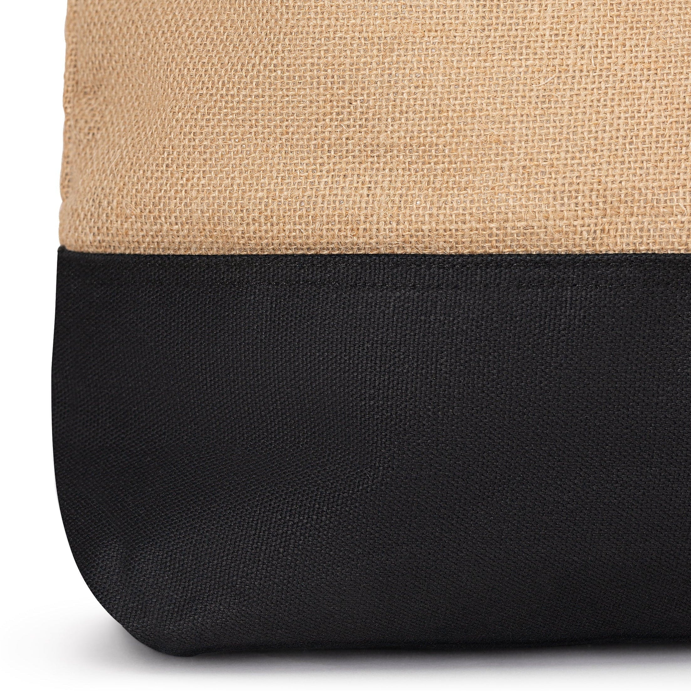 Close-up of a beige and black bag with a visible brand tag on a white background