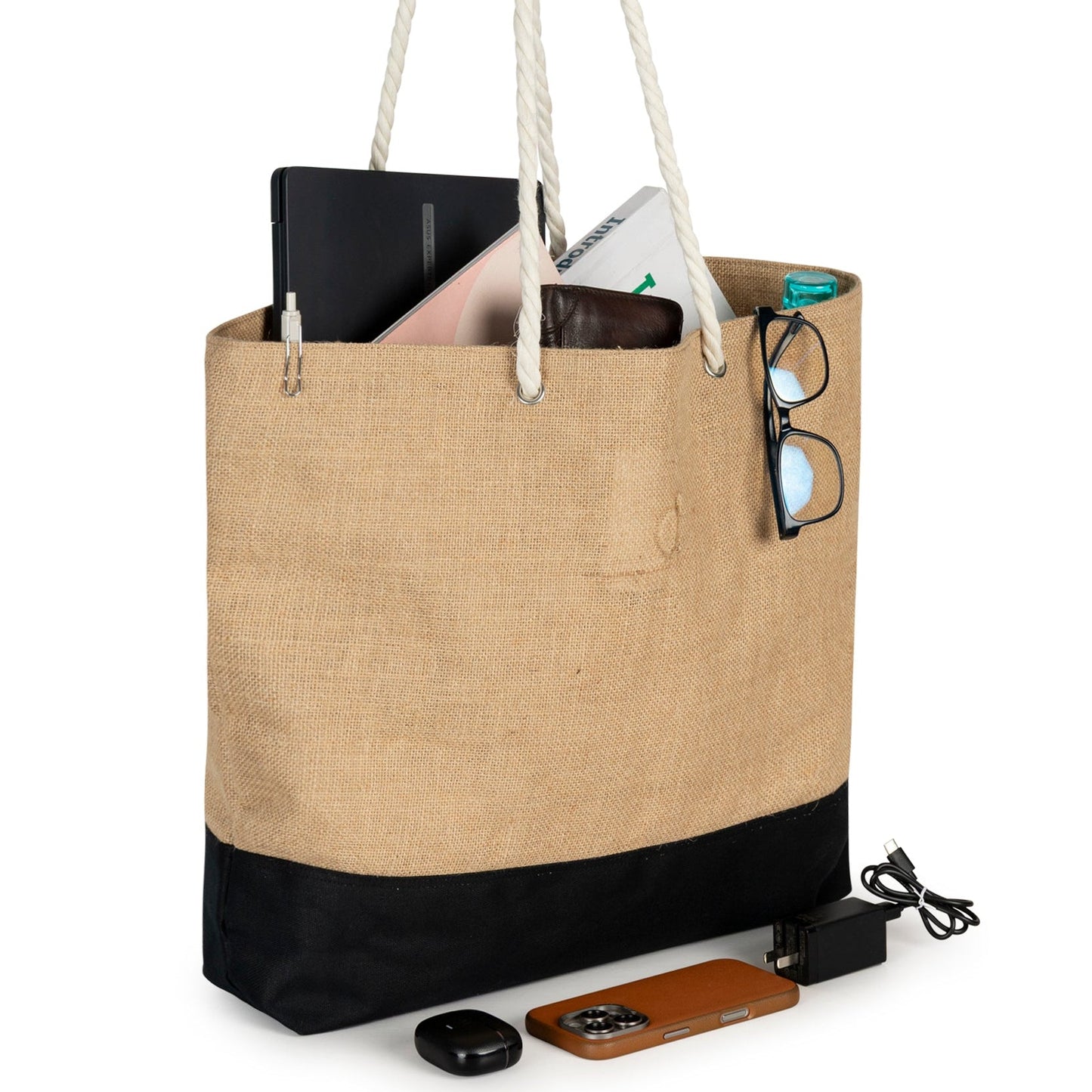 Beige tote bag with black bottom section, containing electronic devices on a white background